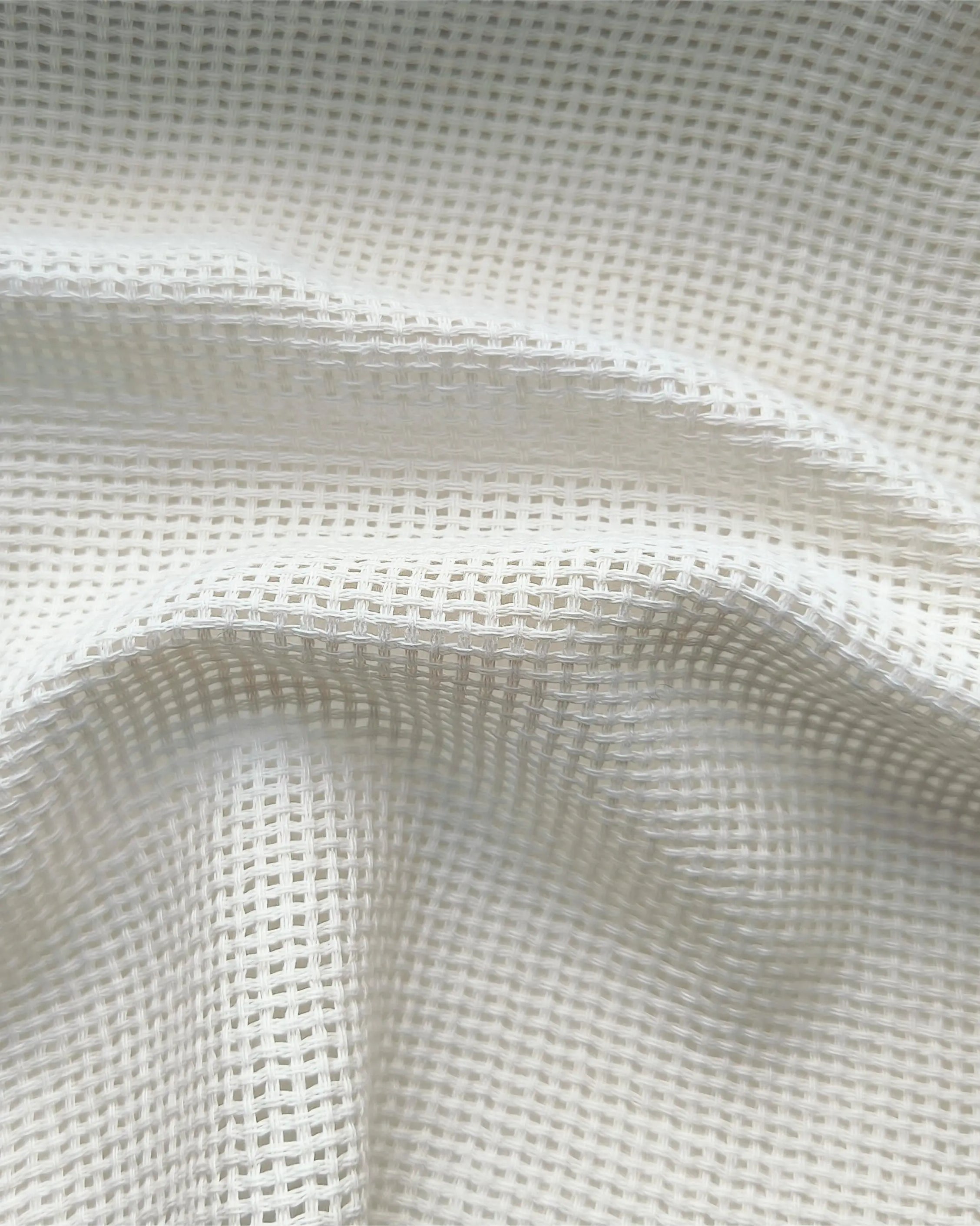 Soft top curtains made of white silk are installed on rods in the living room.