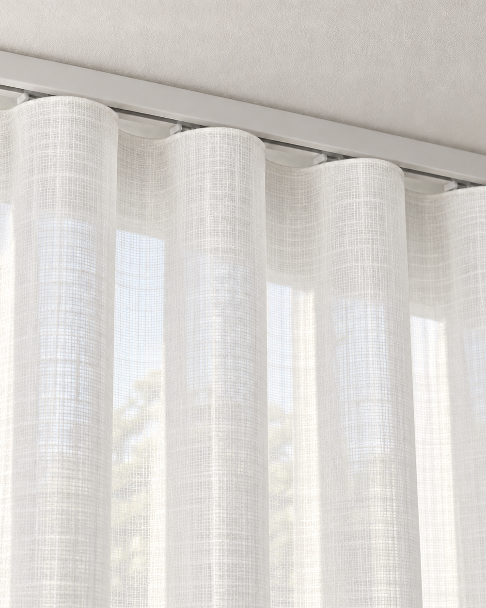Ivory sheer ripple fold curtain close-up beneath a white ceiling track