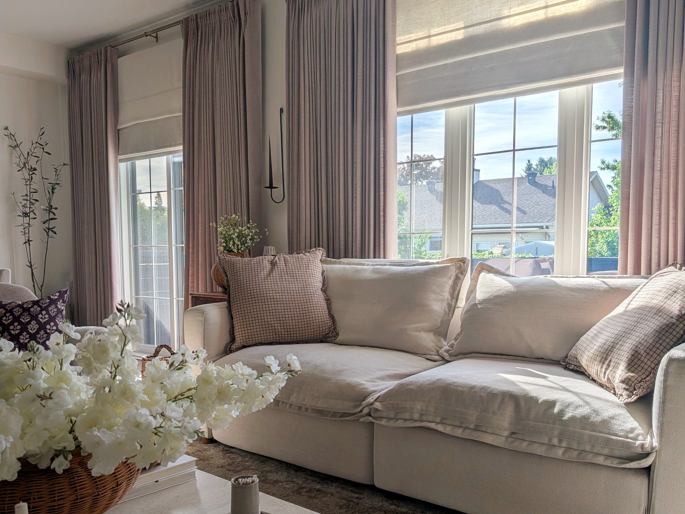 A layered living room with Cozyology drapery and Roman shades