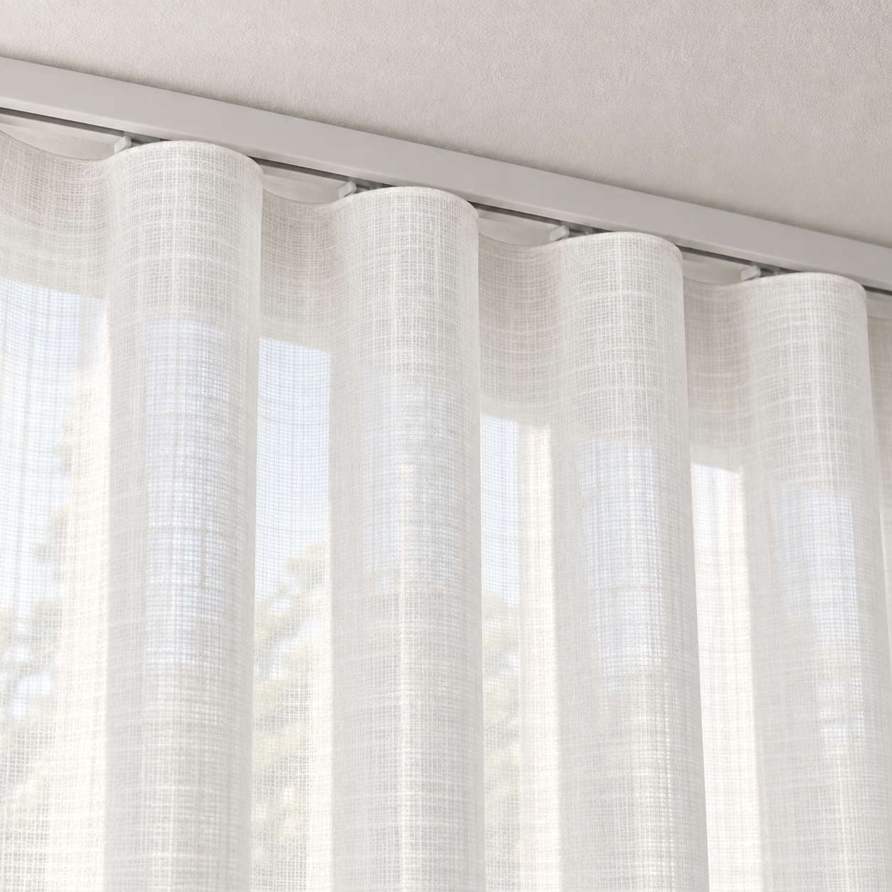Ivory sheer ripple fold curtain close-up beneath a white ceiling track