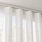 Ivory sheer ripple fold curtain close-up beneath a white ceiling track